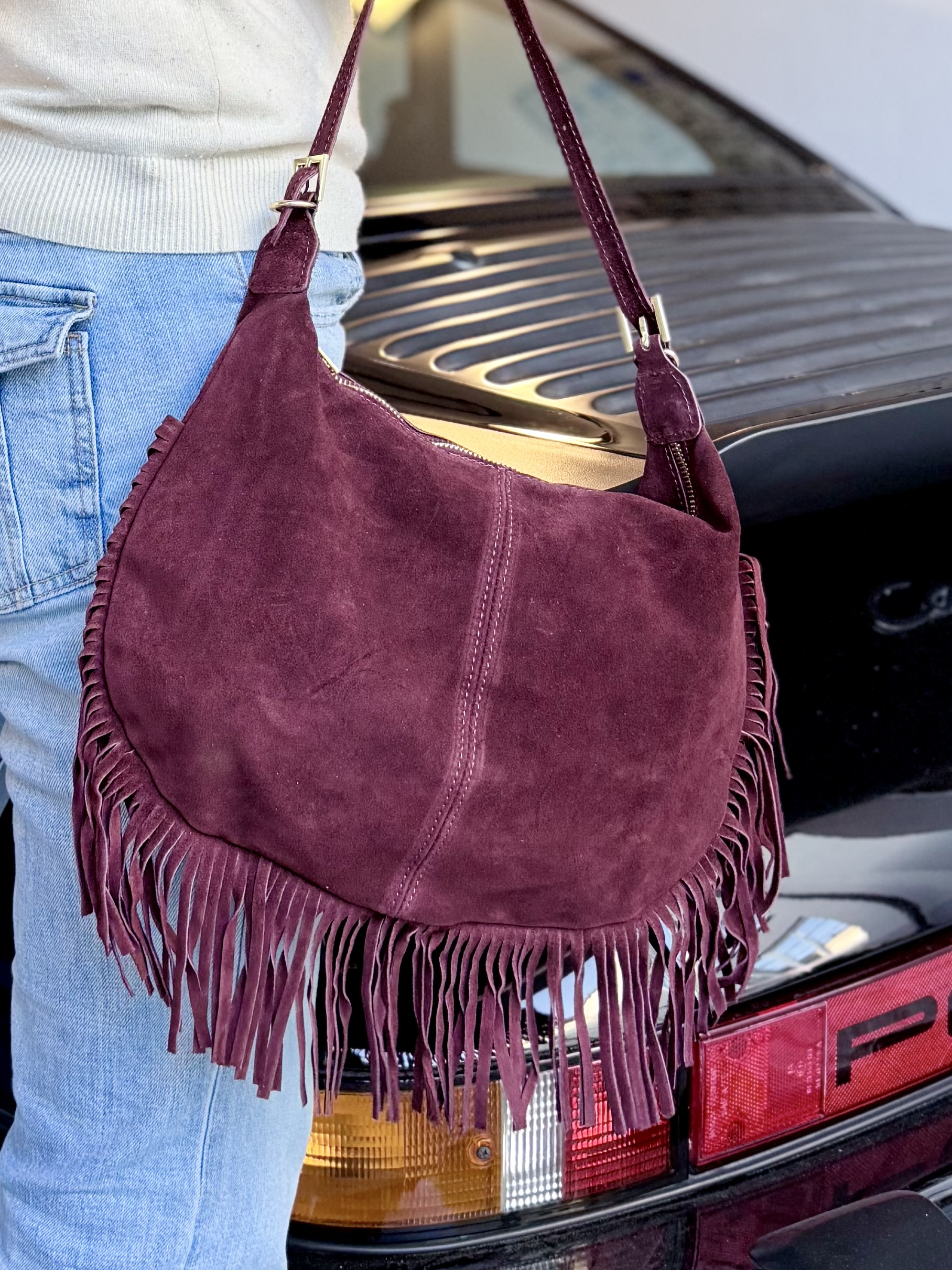 Wildleder Tasche mit Fransen in Bordeaux, über der Schulter getragen zu Jeans