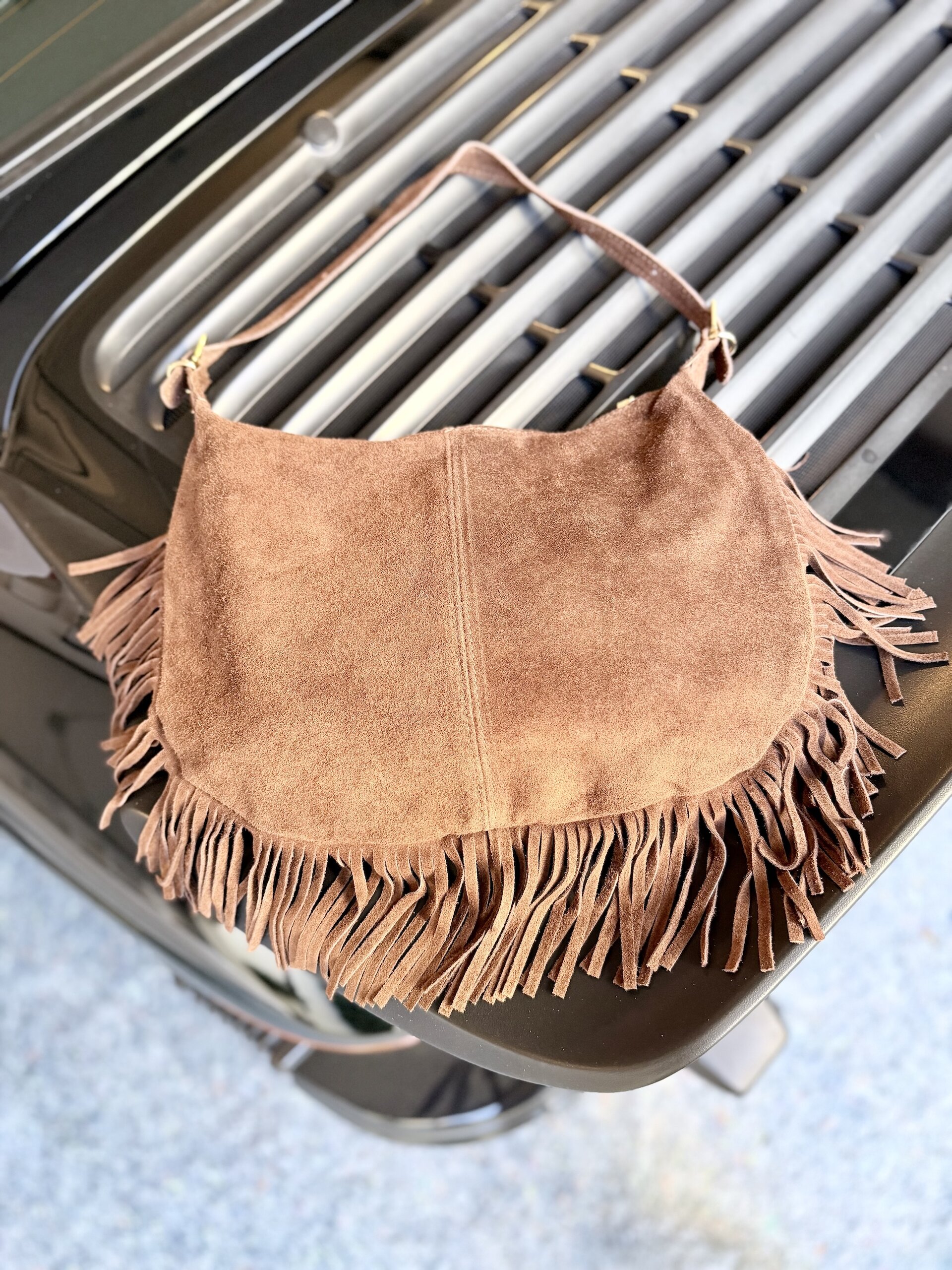 Wildleder Tasche mit Fransen in Cognac auf dem Heck eines Oldtimers