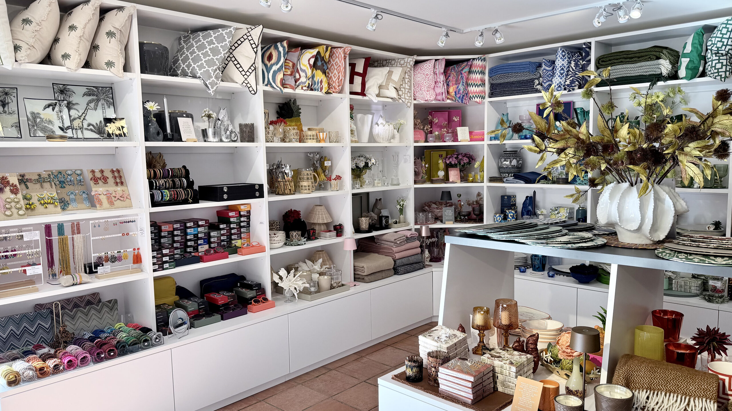 Blick in den KWP Concept Store in Bad Gastein: Regale mit Kissen, Gläsern, Geschirr und Deko